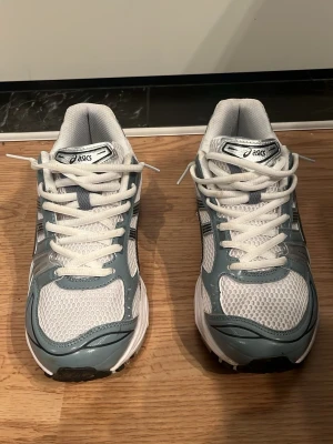 Asics Kayano Vit och blå - Snygga sneakers från Asics i vitt och ljusblått med silvriga detaljer. Endast använda två gånger. Box ingår inte