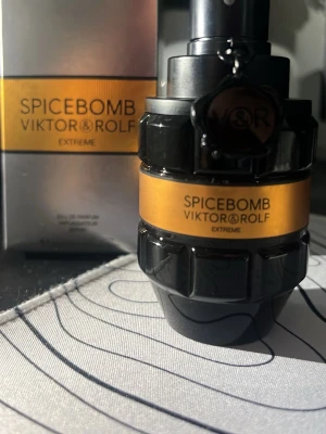 Spicebomb Extreme från Viktor & Rolf - Spicebomb Extreme från Viktor & Rolf är en parfym i en cool, svart och orange flaska som liknar en granat. Doften är intensiv och kryddig, perfekt för dig som gillar starka och unika parfymer. Flaskan är tillverkad av glas och har en snygg metallisk detalj.