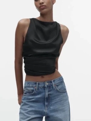 Svart omlott linnetopp i satin - Snygg svart omlott linnetopp i satin med knyt i midjan. Toppen är ärmlös och har en croppad passform som ger en trendig look. Perfekt att styla med jeans eller kjol för en cool outfit. Säljs inte längre. Skriv om det finns några funderingar eller för fler bilder❣️