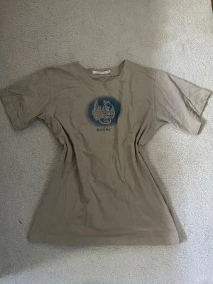 Oversized T-shirt - Snygg beige t-shirt från B-Young med ett blått tryck. Oversized passform med rund hals och korta ärmar 🤍