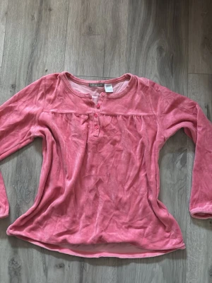 Rosa långärmad topp från Kihawo - Supermjuk rosa långärmad topp från Kihawo med rund halsringning och knappar framtill. Troligen använd som sovtröja. Bra skick !
