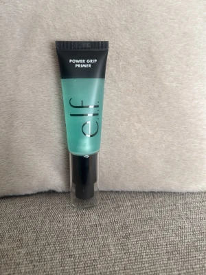 e.l.f. Power Grip Primer - Power Grip Primer från e.l.f. är en transparent, gelbaserad primer i en smidig tub med pump. Den har en ljusblå/grön ton och hjälper sminket att sitta längre samtidigt som den återfuktar huden. Perfekt för att skapa en jämn bas innan foundation.