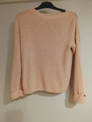 Beige stickad tröja med rund hals HELT NY! - Säljer en beige stickad tröja med rund hals och långa ärmar. Tröjan har en grovstickad struktur och uppvikta ärmslut för en avslappnad look. Perfekt att matcha med jeans eller kjol för en enkel och snygg outfit. RIKTIGT TRENDIG, Snygg & still ren. Helt ny🤌🏼
