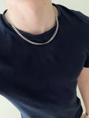 Silverfärgat kedjehalsband - Hej👋 Säljer detta snygga silverfärgat halsband med bred kedja i rostfritt stål🤩 Klassisk design med platt, tätt länkade kedjor och enkel karbinhake😮‍💨 Perfekt accessoar för att lyfta din outfit med en stilren touch🧼 46 cm lång📐Meddela gärna vid frågor📩