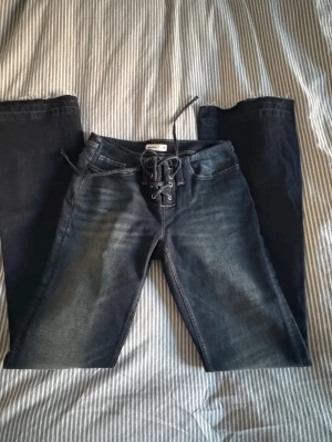 Blå jeans med snörning fram - Blå jeans från Gina tricot med snörning framtil, helt oanvänd i storlek 36