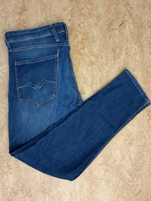 Blå jeans från Replay med raka ben - Snygga blå jeans från Replay med klassisk femficksdesign och raka ben. Jeansen har dekorativa sömmar på bakfickorna och en läderpatch med Replay-logga i midjan. Tillverkade i denim med en autentisk tvättad look.storlek w36 l32