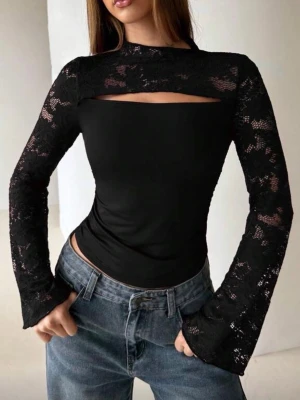 Svart långärmad topp med spets - Trendig svart topp med långa ärmar i spets och en snygg cut-out detalj vid bröstet. Toppen har figurnära passform och hög hals, vilket ger en modern och stilren look. Perfekt att matcha med jeans eller kjol.