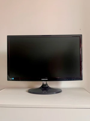 Samsung svart datorskärm - Stilren svart datorskärm från Samsung med rund fot och tunn ram. Skärmen har HDMI- och VGA-portar på baksidan och passar perfekt till både gaming och studier. Modern design i plastmaterial som smälter in på skrivbordet.