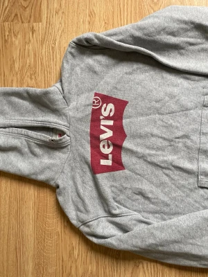 Grå hoodie från Levi's - Säljer en grå hoodie från Levi's eftersom att den inte används längre. Fint skick och sparsamt använd. Väldigt bekväm, varm och avslappnad