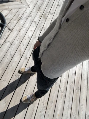Massimo Dutti Cardigan - Ljusgrå stickad kofta med hög krage och åtta stora knappar framtill. Koftan har ribbstickad struktur och långa ärmar, perfekt för lager-på-lager. Enkel och stilren design som passar till det mesta.