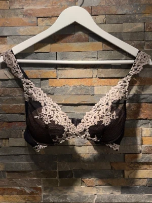 Intimissmi Svart spets-bh med blommig brodyr - Hej!✨Snygg svart bh med transparent mesh och dekorativ blommig spets i beige över kuporna och axelbanden. Bh:n har bygel och breda axelband för extra stöd. Perfekt för dig som gillar en feminin och elegant stil. Jättefin och sparsamt använd! Nypris: 559kr💕💕. 