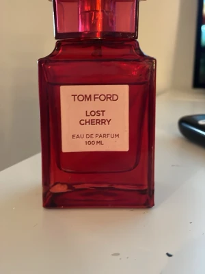 Tom Ford Lost Cherry Eau de Parfum - Tom Ford Lost Cherry Eau de Parfum 100 ml i en snygg, röd glasflaska med stilren etikett. Doften är känd för sina söta och fruktiga toner med inslag av körsbär. Perfekt för dig som vill sticka ut med en lyxig och unik parfym.