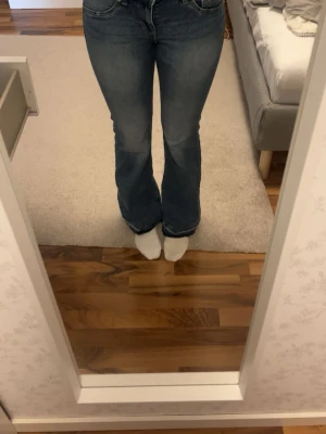 Blå bootcut jeans med rå kant - Säljer ett par blå bootcut jeans som jag har sprättat upp där nere se bild 2. Jeansen har klassisk femficksdesign och är tillverkade i denim med lätt tvättad look. Perfekta för dig som gillar en avslappnad och trendig stil.