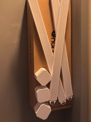 Nanoleaf Lines smarta LED-ljusskenor - Säljer ett set med vita Nanoleaf Lines LED-ljusskenor. Skenorna är avlånga och har sexkantiga kopplingspunkter i plast. Perfekt för att skapa coola ljuseffekter på väggen och styra via app. Kommer i originalkartong. (Expansion pack)