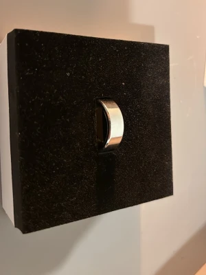 Klassisk bred silverfärgad ring -  Smart Ring – stilren & funktionell – 750 kr  Säljer en smart ring i mycket fint skick. Perfekt för dig som vill hålla koll på hälsa och aktivitet på ett smidigt och diskret sätt utan att bära smartwatch.  Ringen har flera smarta funktioner såsom: • Sömnövervakning   • Pulsmätning   • Stegräkning & aktivitetsmätning   • Modern och stilren design    Ingår: • Originalförpackning   • Laddare   • Manual    Ringen fungerar som den ska och är sparsamt använd.  Pris: 750 kr   Kan hämtas eller skickas 