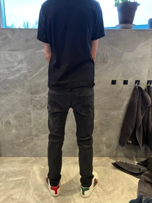 Svarta skinny jeans  - Säljer ett par svarta skinny jeans  med klassisk femficksdesign och låg midja. Jeansen har en tight passform och är tillverkade i stretchigt denimtyg för extra komfort. Perfekta för en clean och stilren look.
