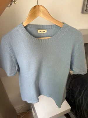 Ljusblå stickad topp från Soft Goat - Superfin ljusblå stickad topp från Soft Goat med rund halsringning och korta ärmar. Enkel och stilren design i mjukt material som känns lyxigt mot huden. Perfekt att styla med jeans eller kjol för en chill look.