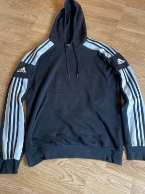 Svart Adidas hoodie  - Svart hoodie från Adidas perfekt för all typ av aktivitet. Rörlig och varm. Säljer pågrund att den inte används längre.