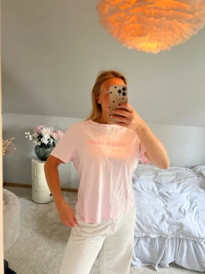 Ljusrosa t-shirt från Aim'n - Säljer en ljusrosa t-shirt från Aim'n med tryckt text framtill. T-shirten har en klassisk passform med korta ärmar och rund halsringning. Tillverkad i mjuk bomull som känns skön mot huden. Perfekt för en avslappnad och trendig look.