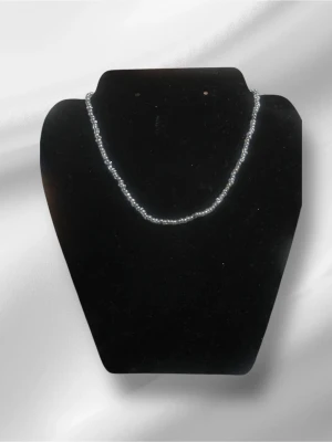 Silvrigt pärlhalsband - Ett stilrent halsband med små, silvriga pärlor som ger en elegant och modern känsla. Halsbandet har en enkel och klassisk design som passar till många olika stilar. Perfekt för dig som gillar minimalistiska accessoarer. Halsbandet är handgjort