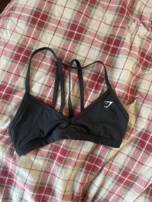 Svart träningstopp från Gymshark - Snygg svart träningstopp från Gymshark. Säljer då den tyvärr ej passar mig längre. Sparsamt använd. Storlek xs 💕