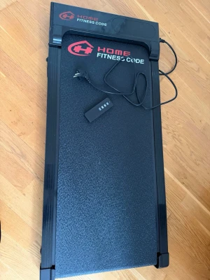 Gångband Home Fitness Code svart - Elektriskt gångband från Home Fitness Code i svart med röda detaljer. Kompakt och smidig design, perfekt för hemmaträning. Utrustad med digital display och fjärrkontroll. Mått: 105x47,5x10,5 cm. Tillverkat i metall och plast. Den är helt ny, köptes 12 februari 2026, använt 2 gånger, orginalpris 2499. Skriv för fler bilder och pris kan diskuteras.
