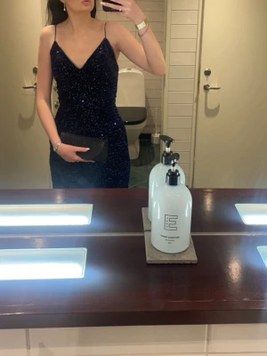 Mörkblå glittrig balklänning med slits & öppen rygg - Säljer min jättefina mörkblå balklänning med glittrig finish – en riktig blickfångare ✨                          Klänningen har en elegant slits, öppen rygg med knytning som gör att passformen kan justeras snyggt. Perfekt till bal, gala eller festligare tillfällen 💃                    Mycket bra skick då den endast är använd en gång, den är bekväm och sitter superfint!                                         Skriv gärna om ni vill ha fler bilder. Pris kan absolut diskuteras 🩷