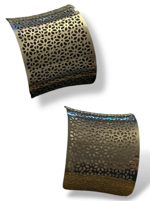 Brett silverfärgat armband med mönster - Snyggt brett armband i silverfärgad metall med ett detaljerat blommigt utskuret mönster. Armbandet har en lätt böjd form och ger en cool statement-look till din outfit. Perfekt för dig som gillar unika accessoarer med lite edge.