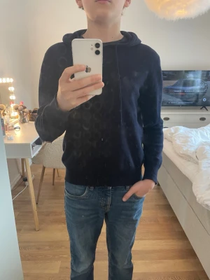 Mörkblå Kashmir hoodie - Säljer en stilren mörkblå kashmir hoodie med huva och dragsnören. Hoodien är från Sayless. Den har 2st hål på armbågarna men de går att sy ihop. Jag köpte den för cirka 900kr, det är storlek XXS!