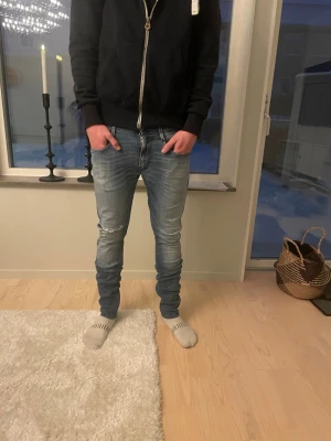 Replay jeans med slitningar  - Tja! Säljer ett par slim fit ljusblå jeans med snygga slitningar på knäna och klassiska fem fickor ifrån replay. Jeansen har en modern passform och är perfekta för en avslappnad stil. Materialet är mjukt och stretchigt för extra komfort. Jeansen är väldigt snygga och väldigt sköna att glida runt i! Modell är replay anbass storlek 31/34 jag på bild är 183🤩skick 10/10🤗hör av dig vid mer frågor eller funderingar🙌🏼mvh premium fashion