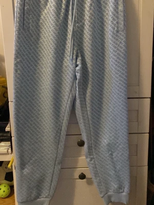 Ljusblåa sopbyxor från FSBN XS - Säljer ett par ljusblåa mj sopbyxor från FSBN med dragsko i midjan och droppat logomönster över hela tyset fact. Perfekta för chill dagar och har en relaxed fit. Materialet känns mjukt och varna sopbyxorna är riktigt sköna att ha på sig.