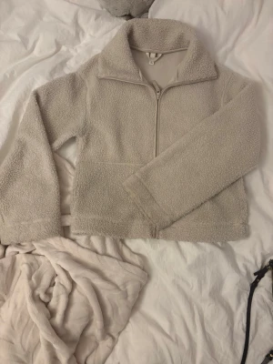 Beige teddyjacka med dragkedja ifrån hm - Supermjuk teddyjacka i beige. Jackan har en avslappnad passform och är gjord i fluffigt teddy-material. Sparsamt använd