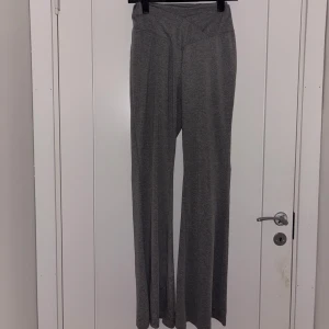 Grå tränings leggings med utsvängda ben - Snygga grå tränings leggings med ribbad  och utsvängda ben. Hög midja och bred linning för en bekväm passform. Perfekta att styla med en oversized hoodie eller crop top.