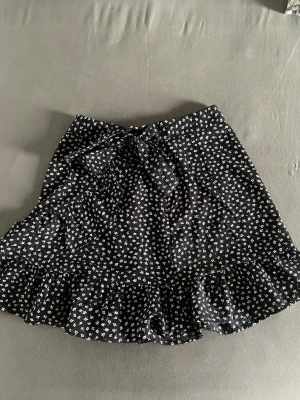 blommig kjol - jätte fin kjol med blommigt mönster och crossover design med dragkedja på sidan och snören för att kunna knyta. aldrig använd