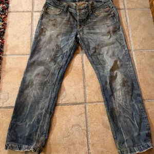 Snygga Dolce & Gabbana jeans - Ett par feta blå dolce & gabbana jeans med rak passform och tydliga slitningar och fläckar som är en del av designen. Benen har ytterst lite heelbite  Midja: 36
