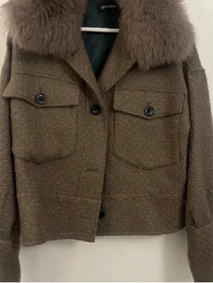 Brun jacka med fuskpäls från Meotine - Säljer nu snygg brun/ grön jacka från Meotine med stor, fluffig krage. 🥰storlek xs/ s men skulle säga att den passar både större och mindre storlekar beroende på hur man vill att passformen ska vara!