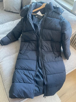 Svart lång dunjacka från lager 157 - Helt oanvänd, prislappen kvar. Blå