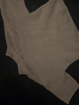 Beige stickad body från Stockh LM - Säljer en beige stickad tröja från Stockh LM i storlek XS. Tröjan har en enkel och stilren design med rund halsringning och Perfekt att styla med jeans eller kjol för en trendig look.