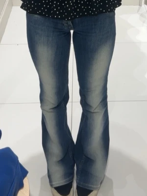 Cheap monday jeans - Snygga blå bootcut jeans med lätt slitna detaljer och tvättade partier längs benen. Jeansen har klassisk femficksdesign och normal midja. Perfekta för en avslappnad och trendig look.
