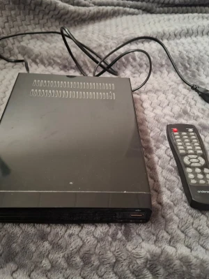 Svart CD-box med fjärrkontroll - Säljer en svart digitalbox från Andersson med tillhörande fjärrkontroll. Boxen har en rektangulär form och är tillverkad i metall och plast. Perfekt för dig som vill koppla in digital-TV eller använda som mediabox. Strömkabel medföljer.