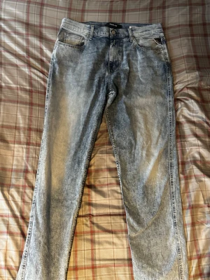 Replay ljusblå tvättade jeans - Snygga ljusblå jeans från Replay med tvättad effekt och klassisk femficksdesign. Jeansen har raka ben och läderpatch med Replay-logga bak i midjan. Perfekta för en avslappnad och trendig stil.