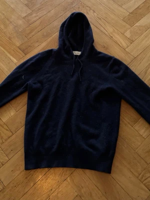 Mörkblå cashmere hoodie Sayless - Snygg mörkblå hoodie från Sayless i mjuk cashmere. Klassisk modell med huva och dragsko, perfekt för dig som vill ha en stilren och bekväm look. Passar lika bra till jeans som till mjukisbyxor. Är i bra skick men säljs för den är för liten. Nypris 999kr. Om du har några frågor är det bara att skriva. Str xxs.