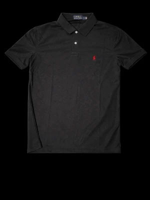 Svart piké från Polo Ralph Lauren - Klassisk svart pikétröja från Polo Ralph Lauren med två knappar och röd broderad logga på bröstet. Skjortan har korta ärmar och mjukt bomullsmaterial som känns skönt mot huden. Perfekt till jeans eller shorts för en clean look.