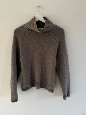 Brun polotröja från Wera - Mysig brun stickad polotröja från Wera med bred ribbad krage och muddar vid ärmslut och nederkant. Tröjan har en avslappnad passform och är perfekt för kalla dagar. Tillverkad i mjukt material som känns skönt mot huden. Bra skick och nypris 799kr.