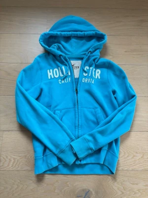 Blå zip vintage hoodie från Hollister - En riktigt fet hollister tröja! Sitter lite för stort på, den sitter som L och har fint skick. Skick:9/10 | modellen är 185cm lång. Pris 599 men kan diskuteras🤩🤩