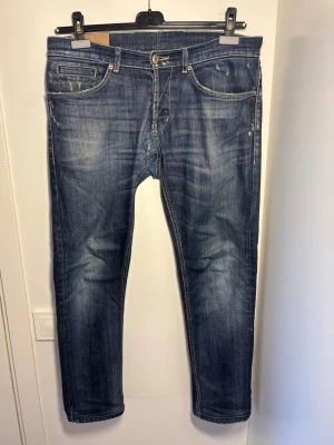 Dondup George - Dondup George jeans i storlek 34 passar 33 o 32. Skick 8/10, sytt hål i greven av professionell skräddare. Pris 449. Fraktar samma dag!