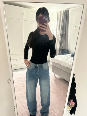 Ljusblåa baggy jeans med hög midja - Säljer ett par ljusblåa baggy jeans med hög midja och raka ben. Jeansen har klassisk femficksdesign och stängs med knapp och dragkedja. Perfekta för en avslappnad och trendig stil.