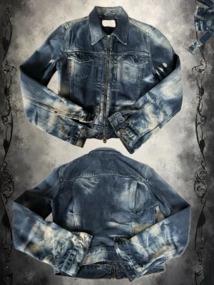 Levis vintage jeansjacka med dragkedja - Säljer en blå jeansjacka från Levi's med coola slitningar och dragkedja framtill. Klassisk modell med två bröstfickor och markerad krage. Jackan har en schysst tvättad look och detaljer som ger en retro känsla. Perfekt för dig som gillar streetwear och denim.