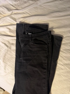 Svarta flared jeans  - Säljer ett par svarta flared jeans från HM. Jeansen har klassisk femficksmodell, bälteshällor och dragkedjegylf. Snygg tvättad svart färg som passar till allt