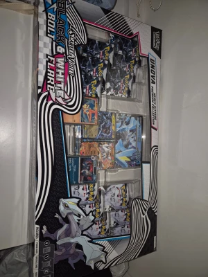 Pokémon Black & White Bolt Flare Box - Stor samlarbox med Pokémon Black & White Bolt Flare-tema. Innehåller flera booster packs, specialkort och exklusiva samlarkort med motiv från Unova-regionen. Förpackningen är svart, vit och blå med grafiska detaljer och Pokémon-illustrationer.